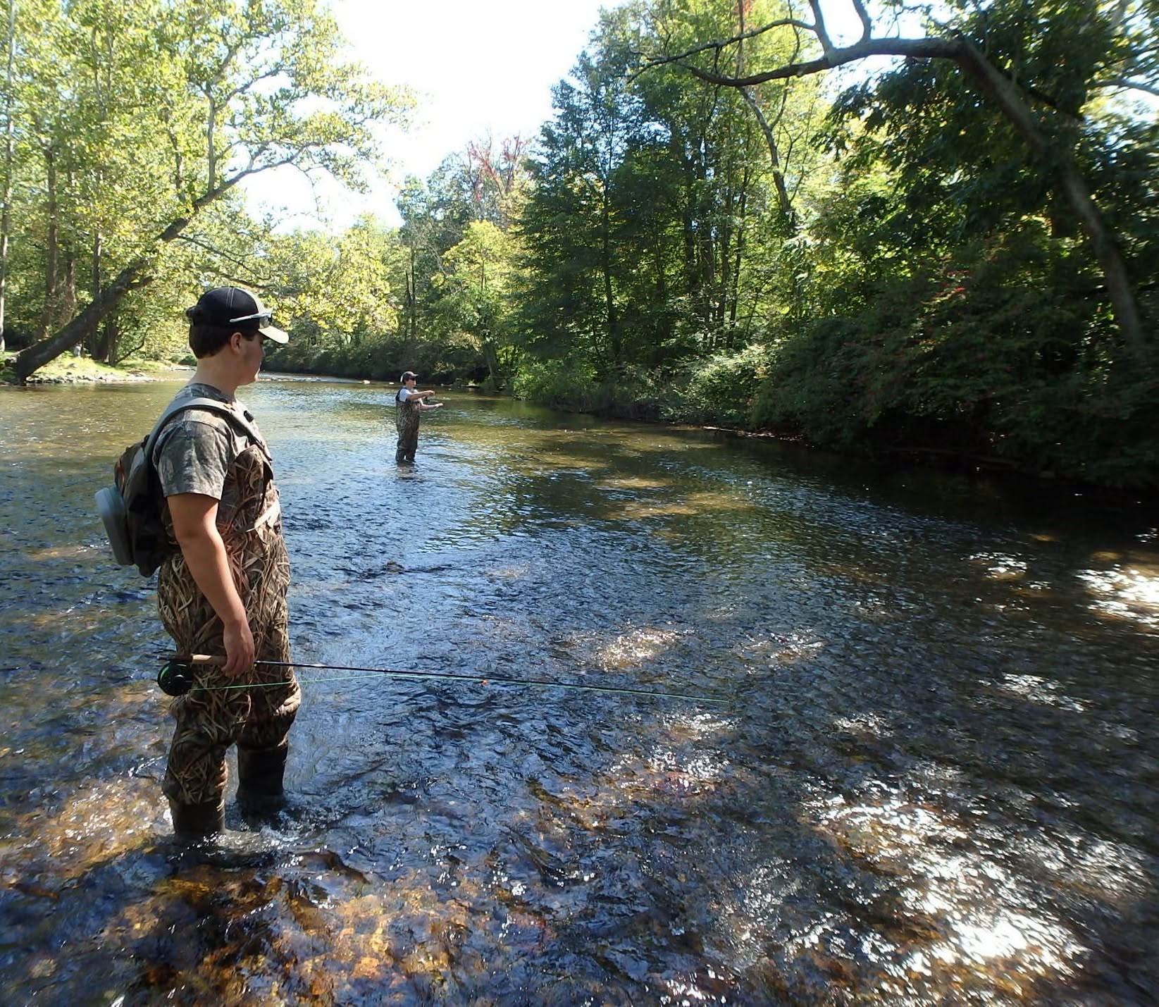 Two teenagers wade into the Yellow Breeches Creek to fly fish.